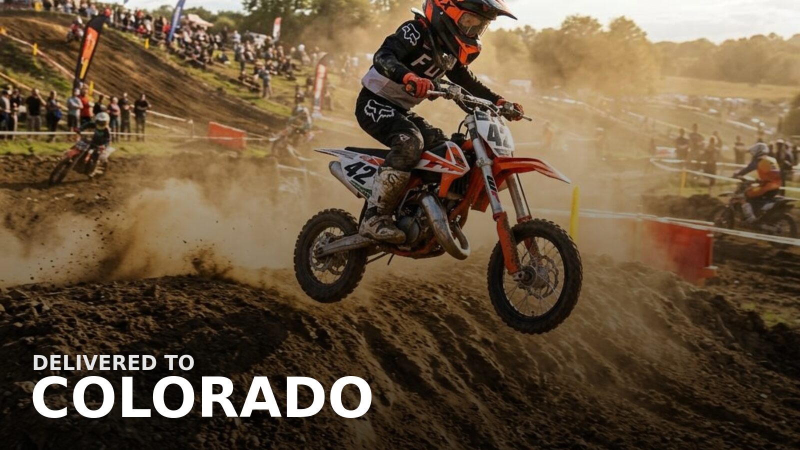 New powersports delivered to Colorado — a dirt bike on an alpine forest trail with peaks behind